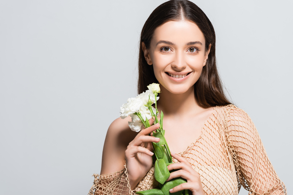 beautiful smiling brunette woman with white carnations isolated on grey - Photo, Image