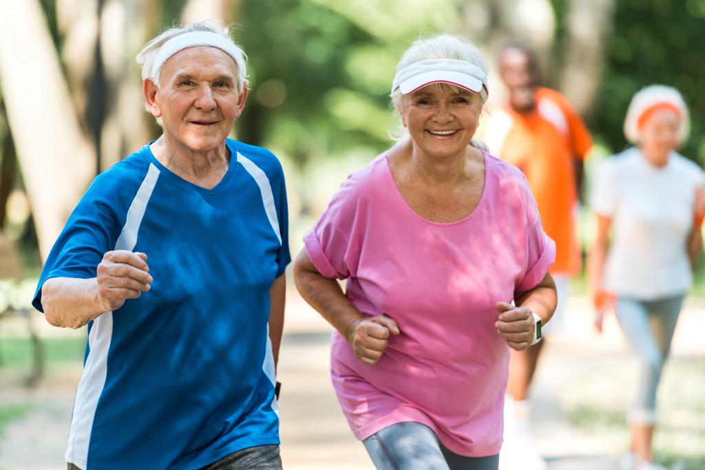 foco seletivo de casal aposentado alegre exercitando fora
  - Foto, Imagem