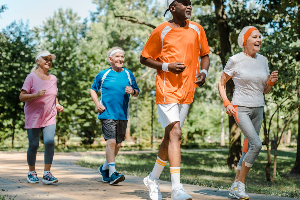 sportliche multikulturelle und pensionierte Männer und Frauen, die im Park laufen  - Foto, Bild