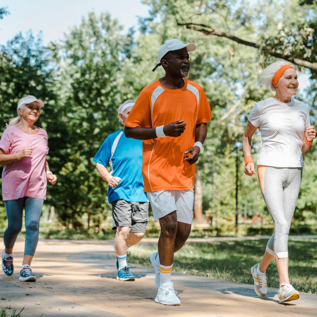 Selektiver Fokus fröhlicher multikultureller und älterer Männer und Frauen, die im Park laufen  - Foto, Bild