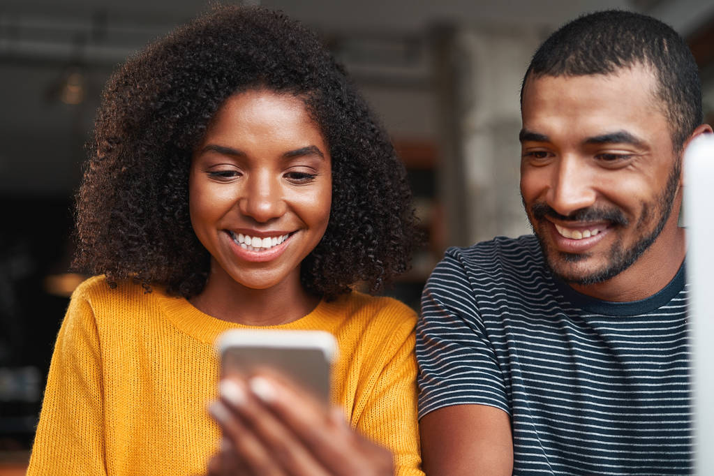Sonriendo pareja africana mirando el teléfono celular sonriendo
 - Foto, Imagen