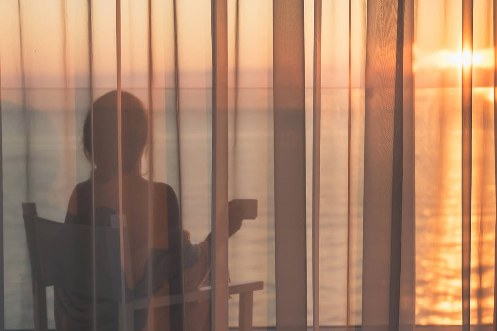 жінка на балконі на фоні заходу сонця
 - Фото, зображення