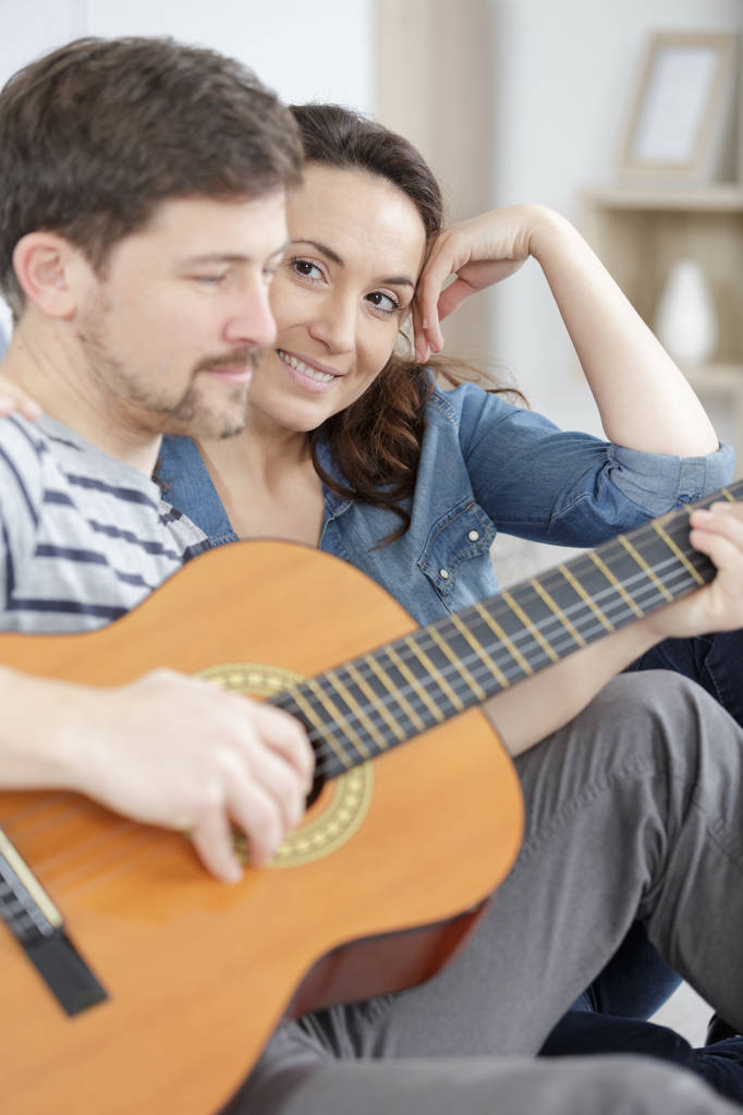 homem tocando guitarra para esposa grávida
 - Foto, Imagem