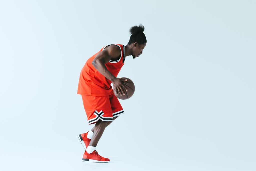 urheilullinen afrikkalainen amerikkalainen urheilija pelaa koripalloa harmaalla pohjalla
 - Valokuva, kuva