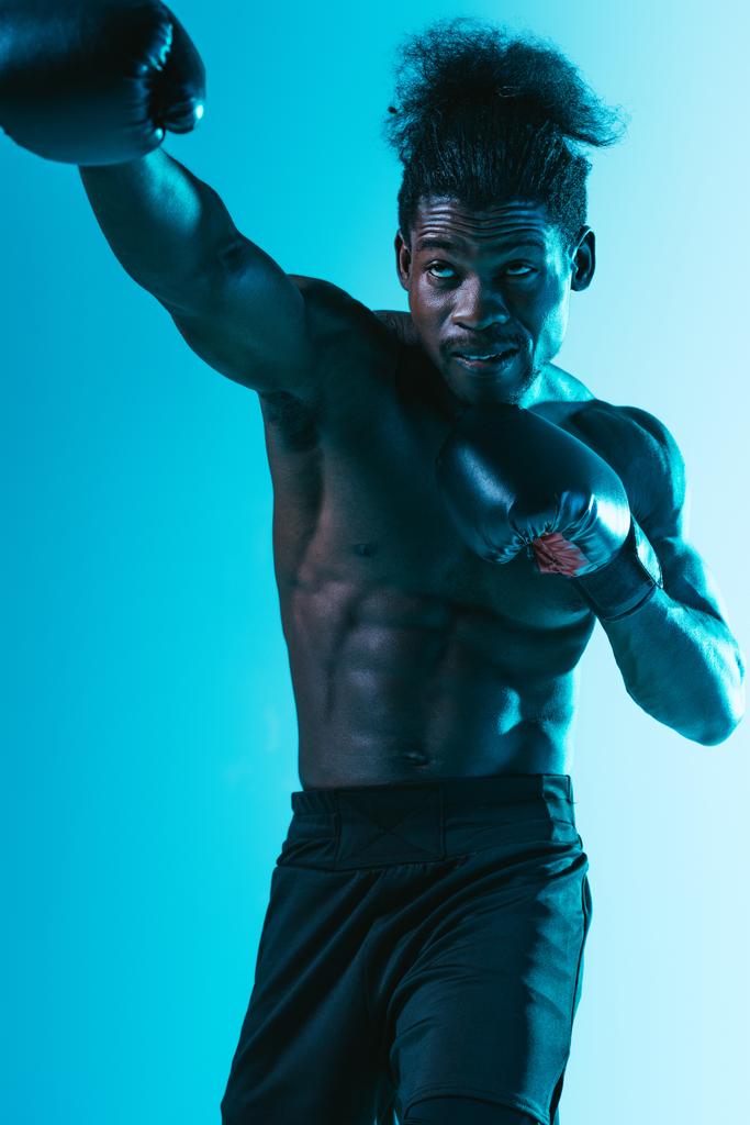 sin camisa, musculoso afroamericano deportista boxeo sobre fondo azul
 - Foto, Imagen