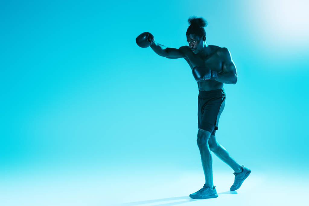 fiducioso sportivo afroamericano in guanti da boxe formazione su sfondo blu
 - Foto, immagini