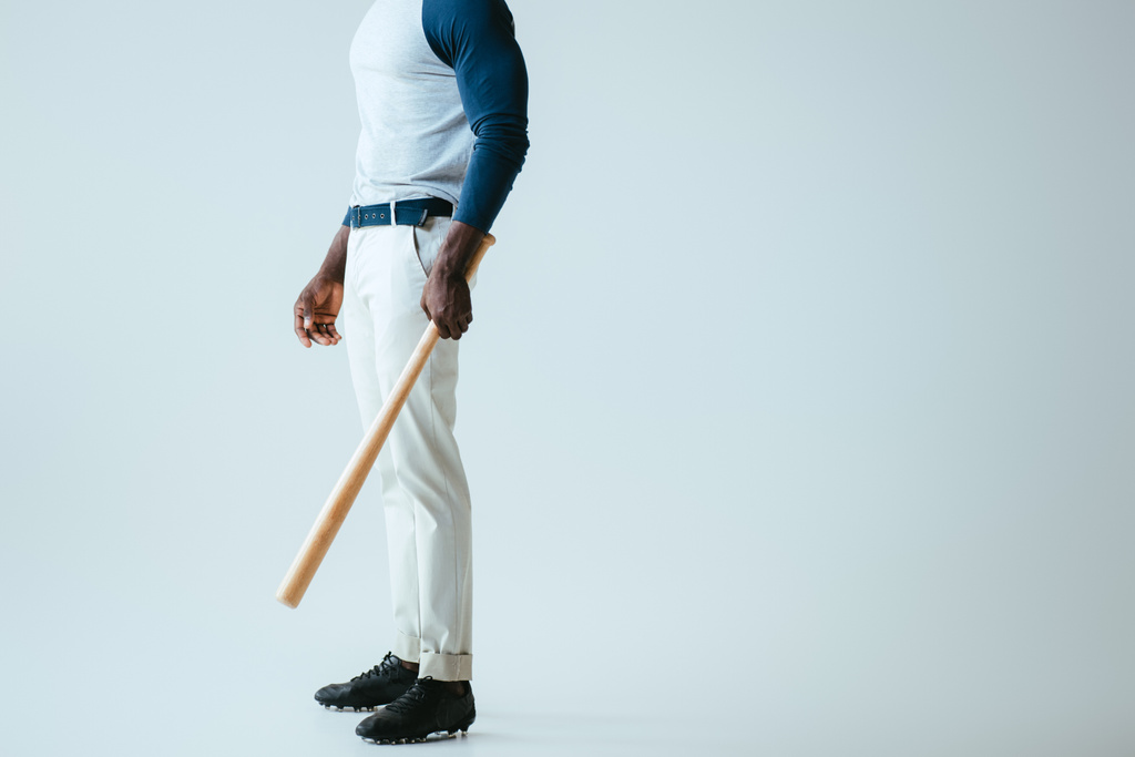 vista parcial del deportista afroamericano con bate de béisbol sobre fondo gris
 - Foto, imagen