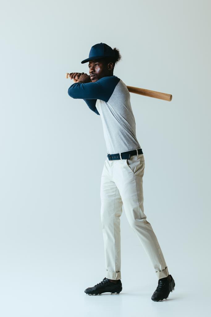 komea afrikkalainen amerikkalainen urheilija pelaa baseballia harmaalla taustalla
 - Valokuva, kuva