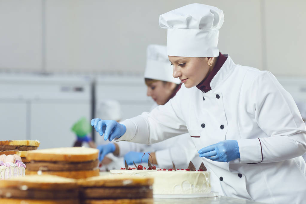 Confiseur avec gâteau pâtissier à la main à la boulangerie
. - Photo, image