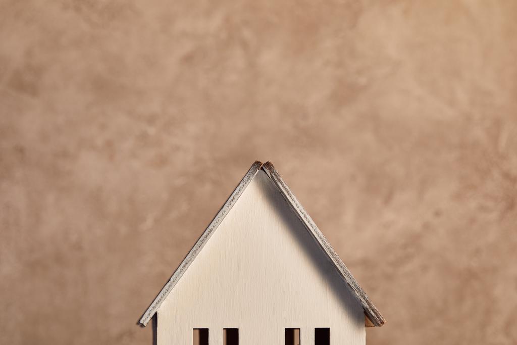 střecha modelu domu v blízkosti béžové textury, koncepce nemovitostí - Fotografie, Obrázek