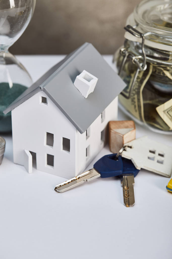 modelo de casa en mesa blanca con llaves y caja de dinero, concepto de bienes raíces
 - Foto, Imagen
