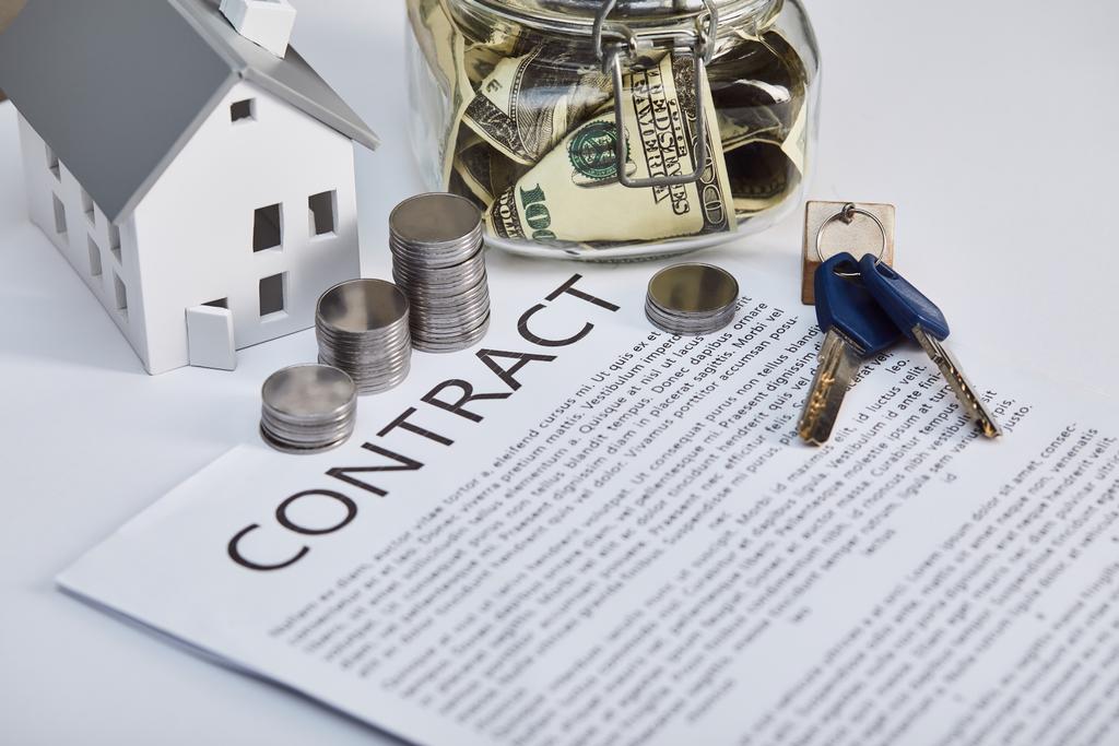 modèle de maison sur table blanche avec contrat, clés et pièces d'argent, concept immobilier
 - Photo, image