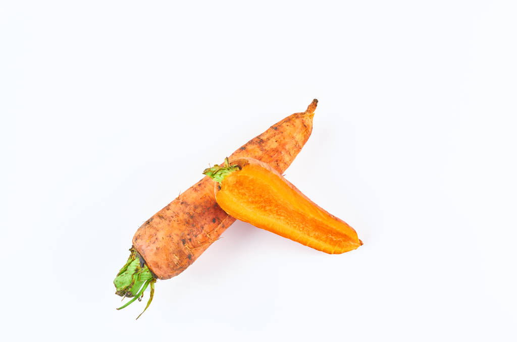 Φρεσκοκομμένα καρότα σε λευκό φόντο, πάνω θέα. Φόντο των βιολογικών τροφίμων. - Φωτογραφία, εικόνα