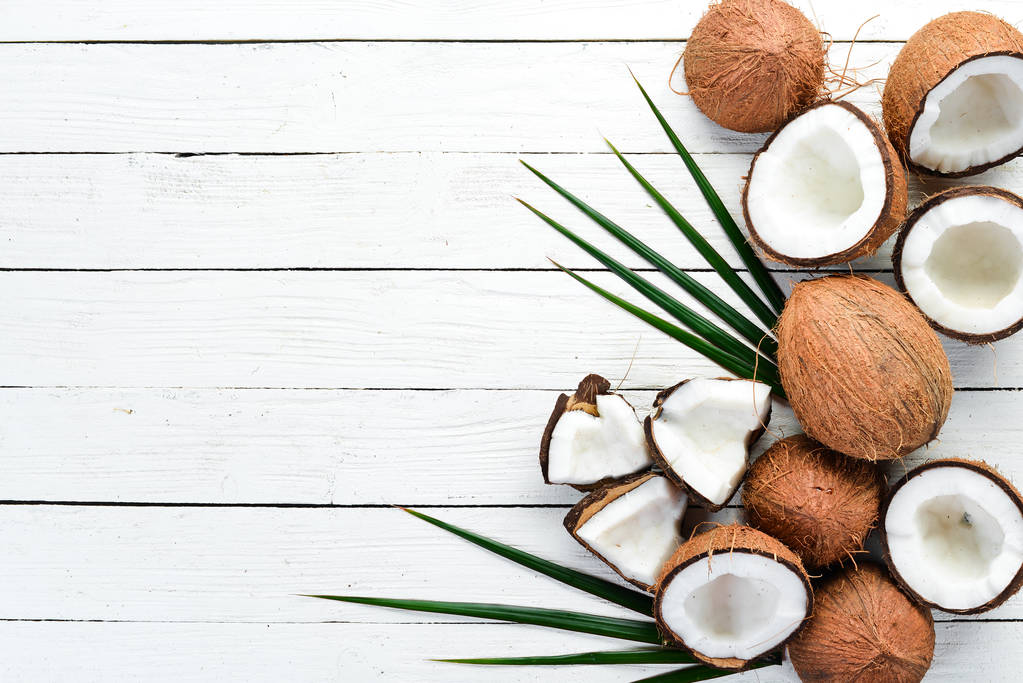 Fresh coconut on a white wooden background. Tropical Fruits. Nut. Top view. Free space for your text. - Photo, Image