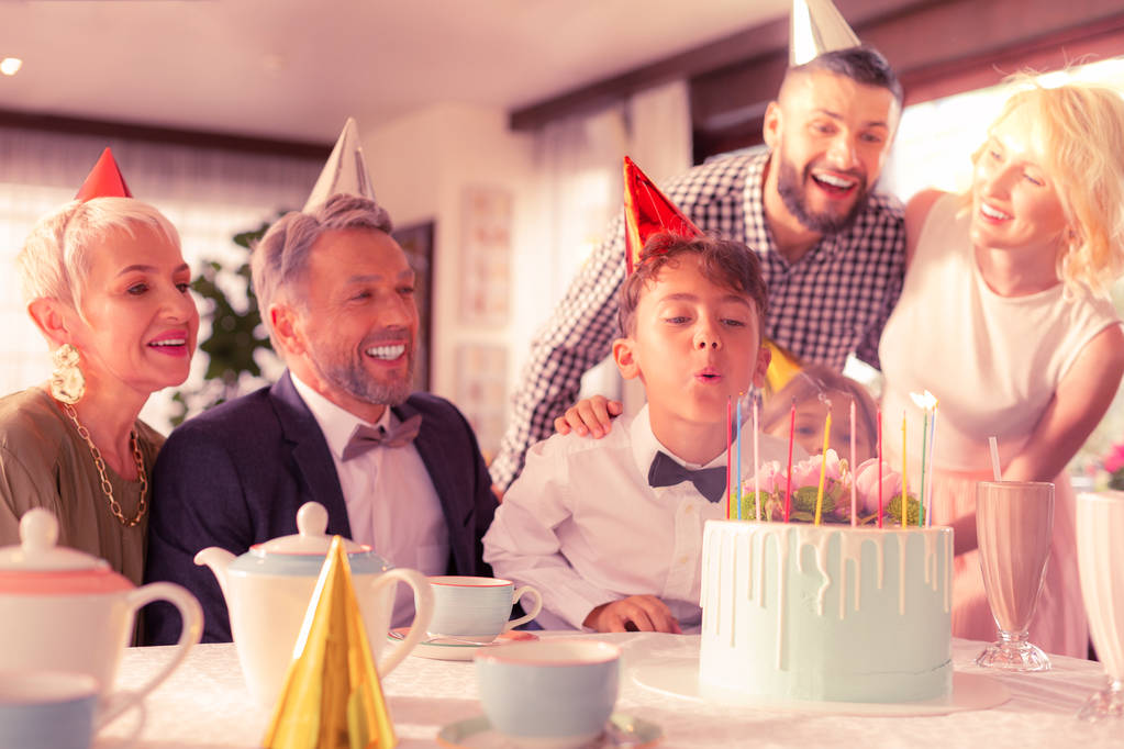 moreno cumpleaños chico soplando velas en su delicioso pastel
 - Foto, imagen