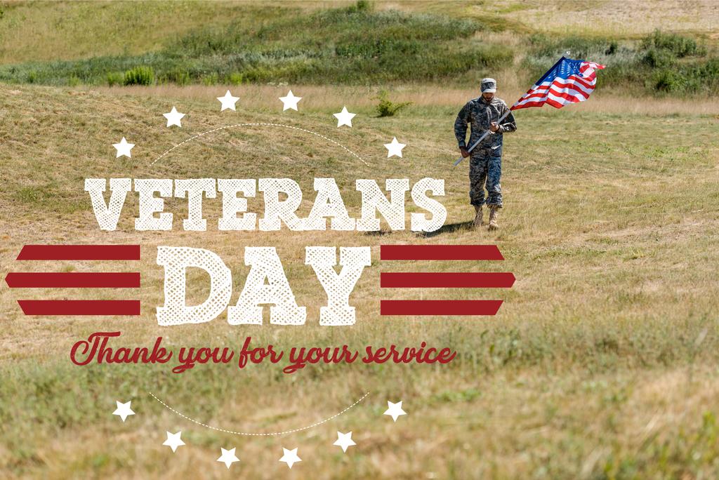 όμορφος στρατιώτης σε ομοιόμορφη περπάτημα και κρατώντας αμερικάνικη σημαία το καλοκαίρι με την ημέρα των βετεράνων, σας ευχαριστώ για την εικόνα της υπηρεσίας σας - Φωτογραφία, εικόνα