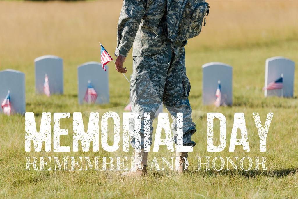 περικομμένη θέα του στρατιωτικού ανθρώπου που κατέχει αμερικάνικη σημαία κοντά σε κεφαλόλιθους στο νεκροταφείο με την ημέρα της μνήμης, να θυμόμαστε και να τιμούμε την εικόνα - Φωτογραφία, εικόνα