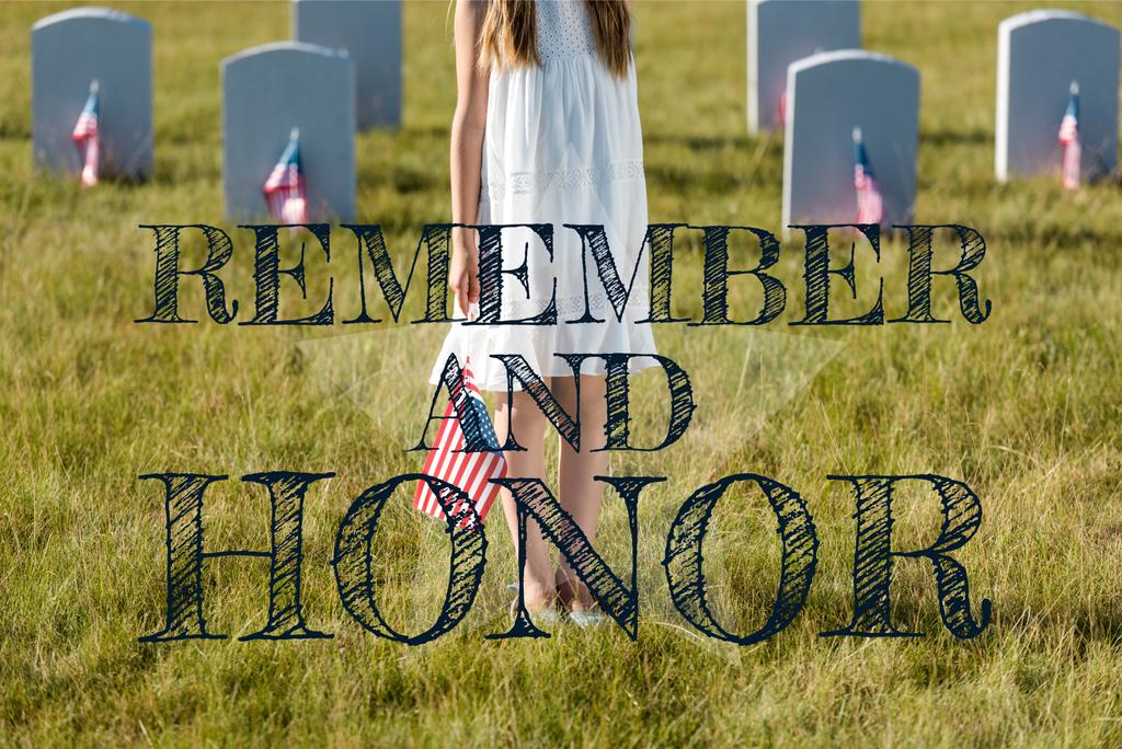 vista cortada da criança em vestido branco em pé no cemitério com bandeira americana com lembrar e ilustração de honra
 - Foto, Imagem