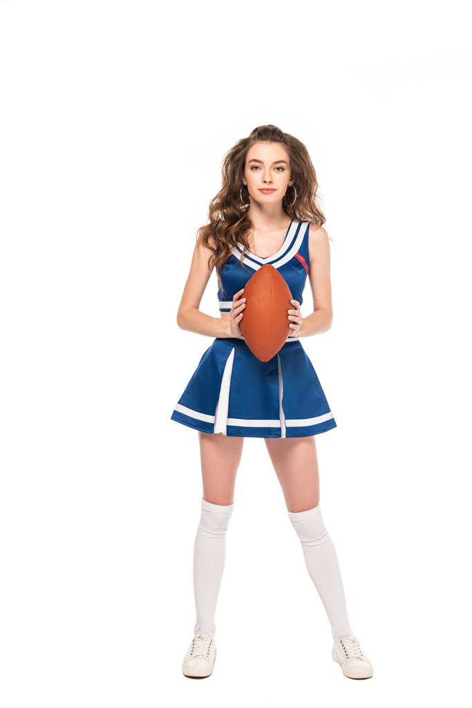 青いユニフォームを着たセクシーなチアリーダーの女の子の全長の景色は、白に隔離されたラグビーボールを保持 - 写真・画像