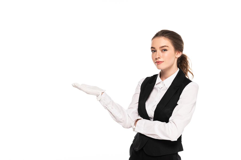 jovem garçonete em uso formal e luvas brancas apontando com a mão isolada em branco
 - Foto, Imagem