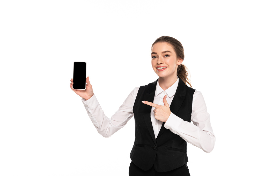 happy young waitress pointing with finger at blank screen on smartphone isolated on white - Photo, Image