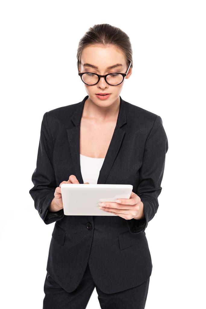 jonge succesvolle zakenvrouw in zwart pak en glazen met behulp van digitale Tablet geïsoleerd op wit - Foto, afbeelding