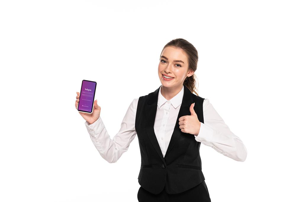 Kijów, Ukraina-7 kwietnia 2019: szczęśliwa młoda kelnerka trzyma smartfon z aplikacją Instagram i pokazuje kciuk w górę na białym tle - Zdjęcie, obraz