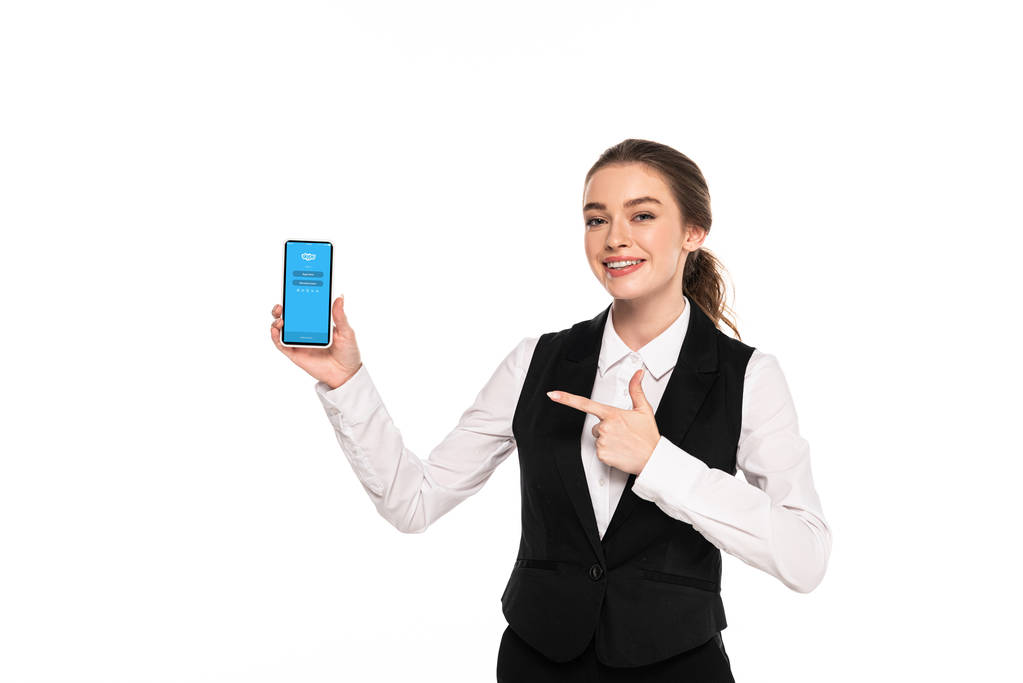 kyiv, ukraine - 7. April 2019: glückliche junge Kellnerin zeigt mit dem Finger auf Skype-App auf Smartphone - Foto, Bild