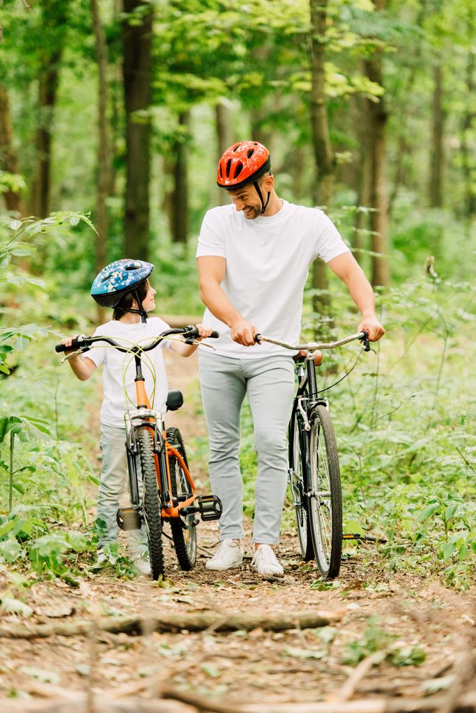 ormanda bisikletle yürüyen baba ve oğulun tam boy görünümü - Fotoğraf, Görsel