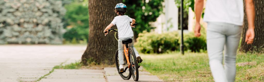 父親が息子の後を歩いている間に自転車に乗る子供のパノラマビュー - 写真・画像