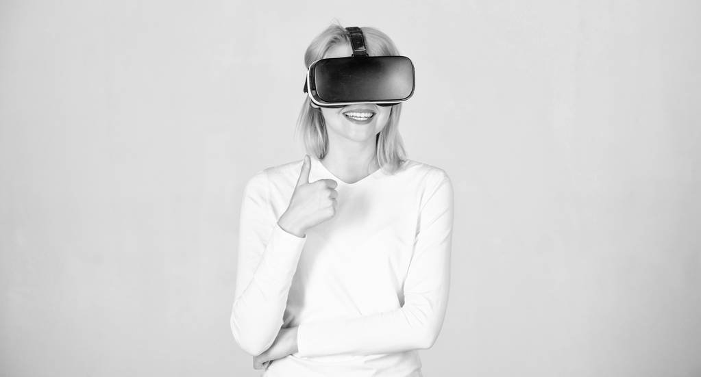 Portret kobiety w białej bluzkę z okularami wirtualnej rzeczywistości na głowie izolowane na szarym tle. Osoba z hełmem wirtualnej rzeczywistości wyizolowana na szarym tle. Kobieta w VR. - Zdjęcie, obraz