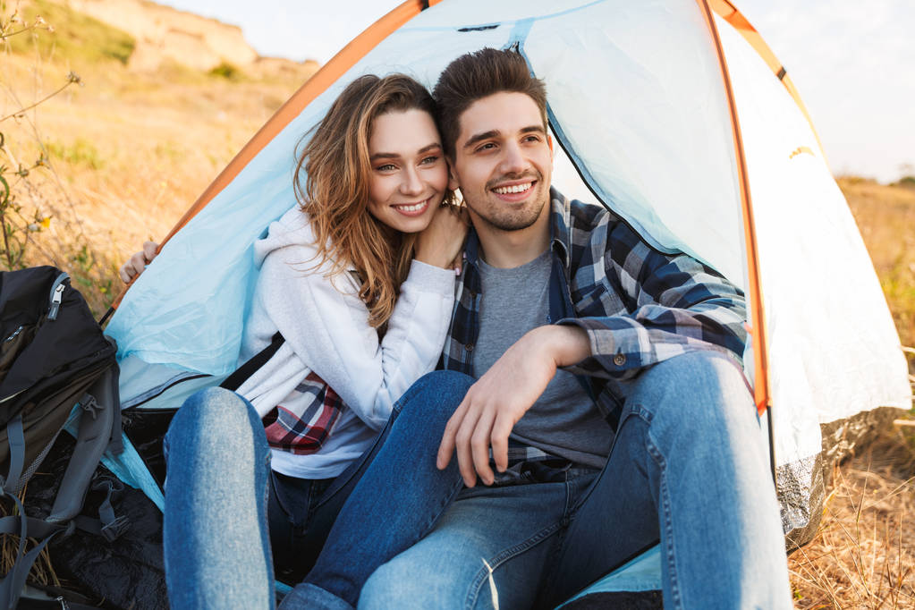 Happy young loving couple outside in free alternative vacation camping. - Photo, Image