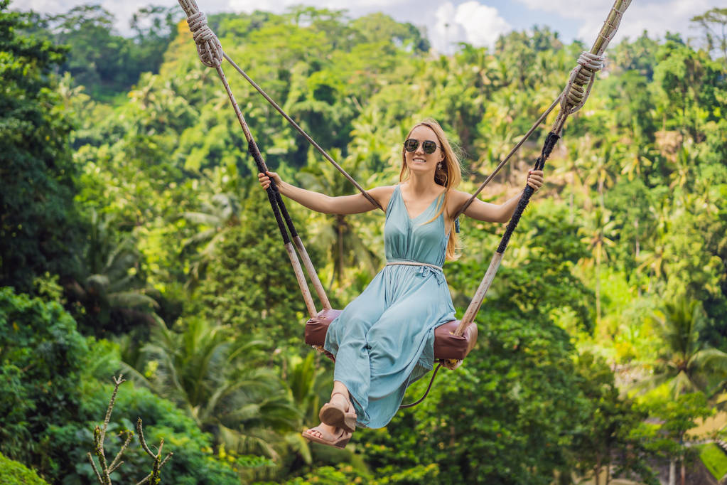 Endonezya'nın Bali adasının orman yağmur ormanlarında sallanan genç bir kadın. Tropik lerde salıncak. Swings - Bali trendi - Fotoğraf, Görsel