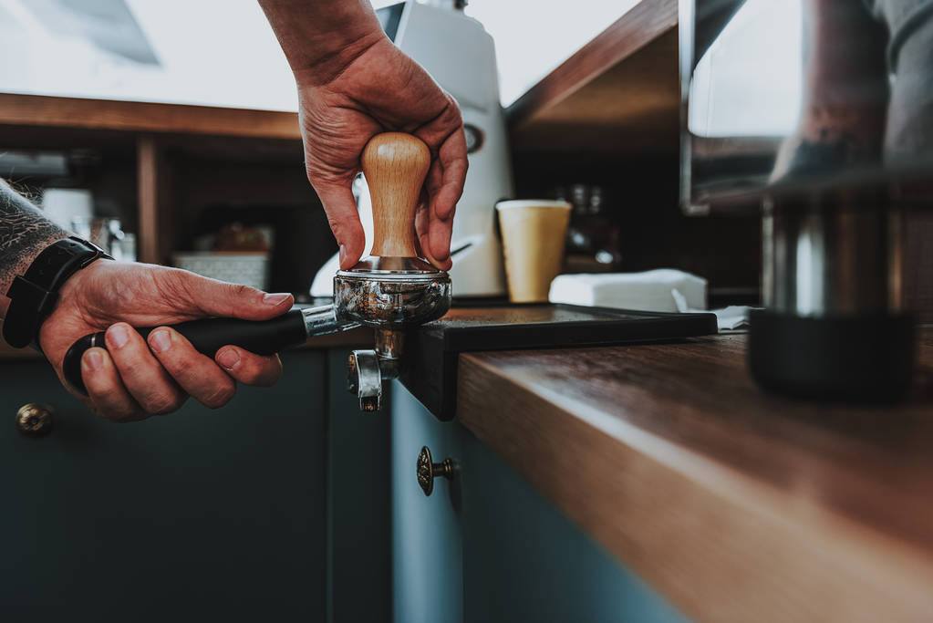 Vita di calma barista premendo il caffè nel portafiltro
 - Foto, immagini