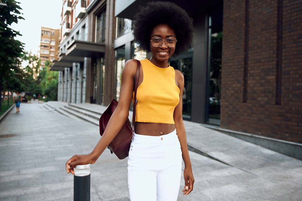 Mujer bastante afroamericana disfrutando mientras camina por la calle
 - Foto, Imagen