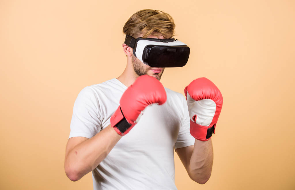 Guantes de boxeo para deportistas cibernéticos. Juego de hombre en gafas VR. Concepto de ciberdeporte. Hombre boxeador simulador de auriculares de realidad virtual. Entrenamiento cibernético en línea. Explora el ciberespacio. Mundo 3D aumentado
 - Foto, Imagen