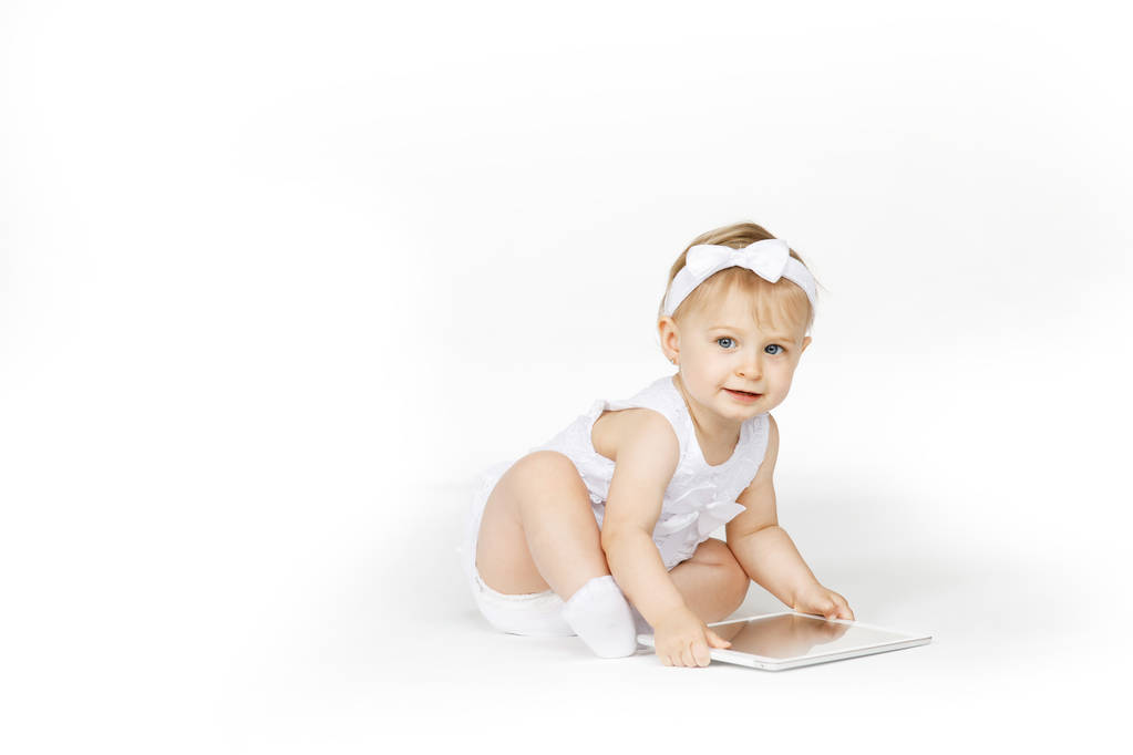 μικρό κορίτσι όλα σε λευκό με ένα δισκίο - Φωτογραφία, εικόνα