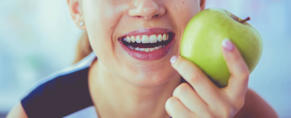 Nahaufnahme Porträt einer gesunden lächelnden Frau mit grünem Apfel. - Foto, Bild