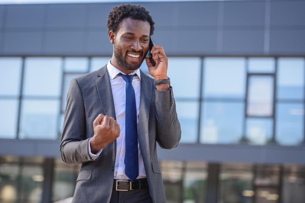 heureux homme d'affaires afro-américain montrant oui geste tout en parlant sur smartphone
 - Photo, image