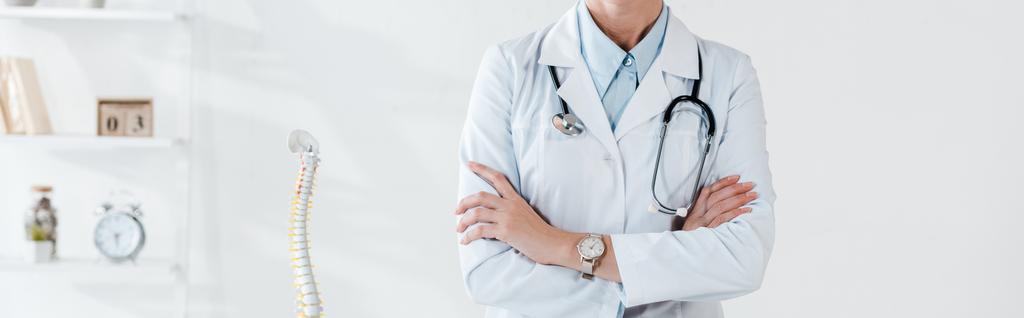 panoramatický záběr lékaře stojícího s zkřížené náručí v nemocnici  - Fotografie, Obrázek