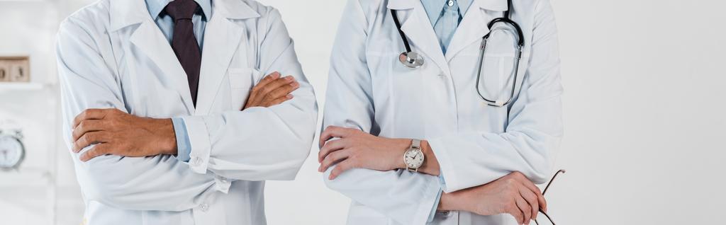 πανοραμική βολή γιατρών που στέκονται με σταυρωτά μπράτσα στην κλινική  - Φωτογραφία, εικόνα