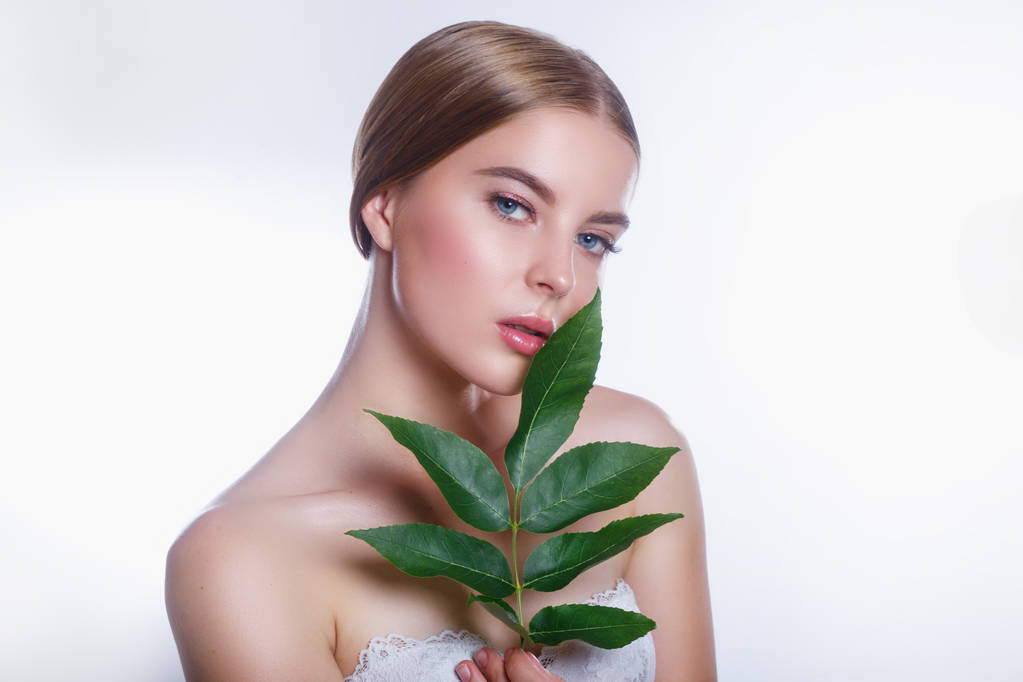 Όμορφη γυναίκα πρόσωπο πορτρέτο με πράσινο φύλλο αντίληψη για τη φροντίδα του δέρματος ή βιολογικά καλλυντικά - Φωτογραφία, εικόνα