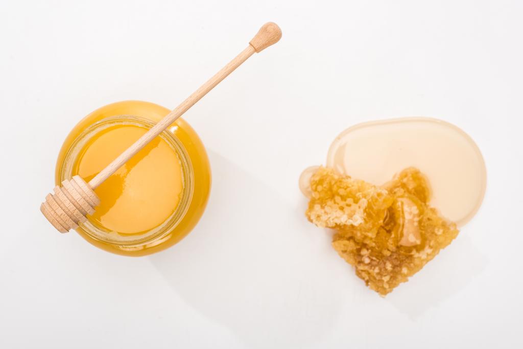 vista superior do frasco com mel, favo de mel e mel de madeira dipper no fundo branco
 - Foto, Imagem
