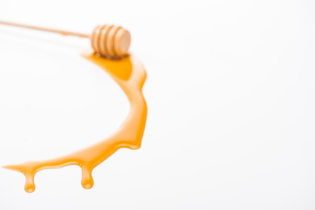dripping honey and wooden honey dipper isolated on white with copy space - Photo, Image