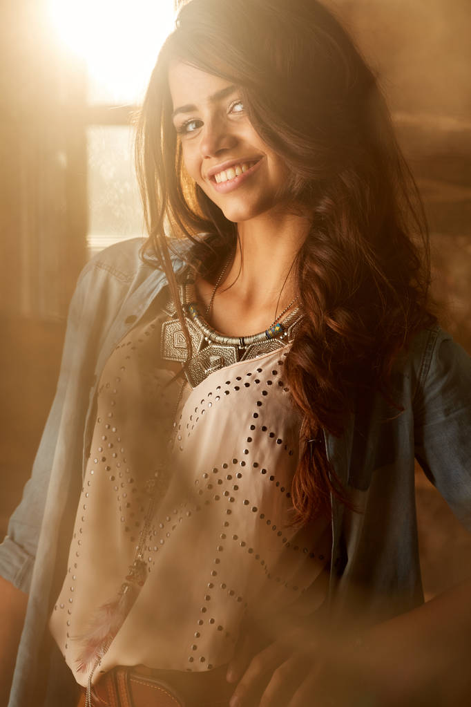 Боковой портрет улыбающейся молодой женщины, стоящей у окна
 - Фото, изображение
