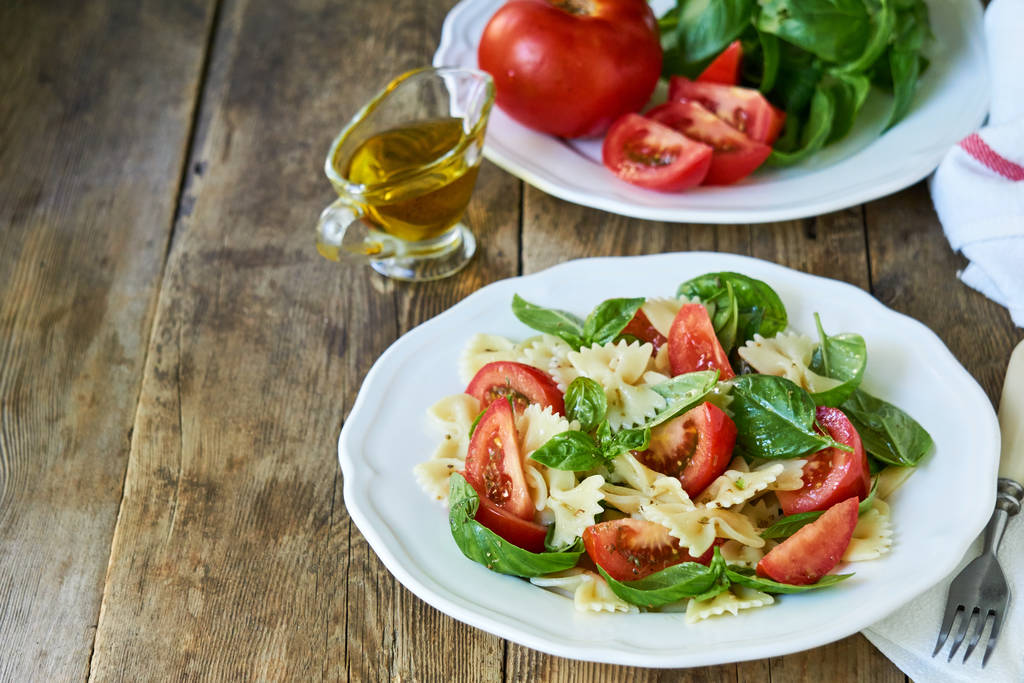 Farfalle pasta salad with tomatoes and green basil                                   - Photo, Image