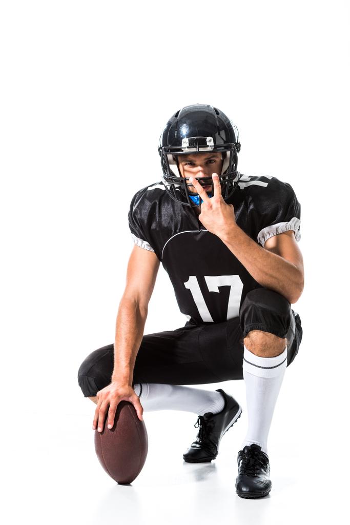 American Football speler met bal tonen vredesteken op wit - Foto, afbeelding