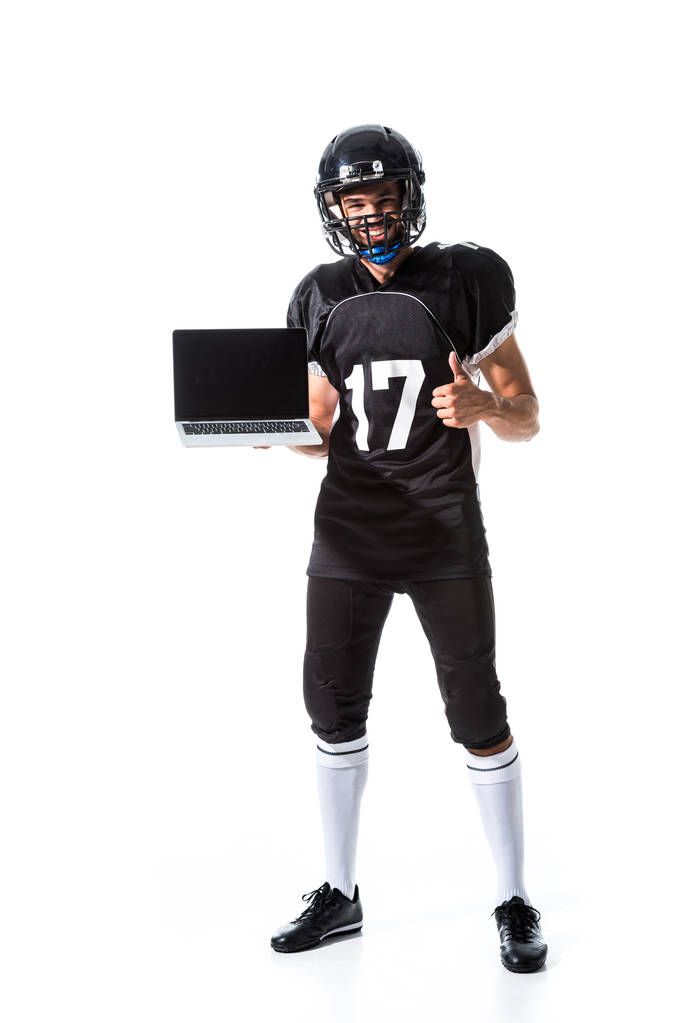 American Football speler met laptop weergegeven duim omhoog geïsoleerd op wit - Foto, afbeelding