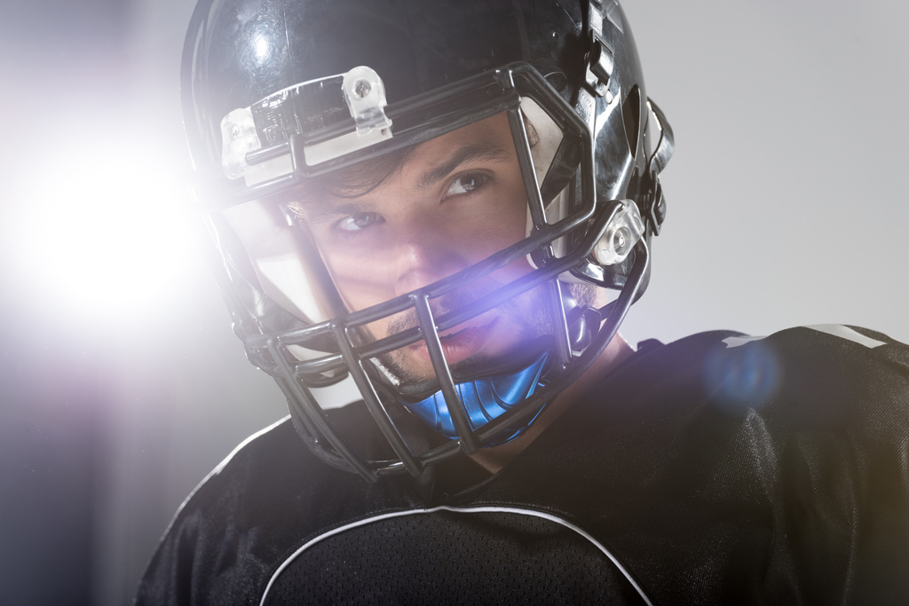 Американский футболист в шлеме на сером с подсветкой
 - Фото, изображение