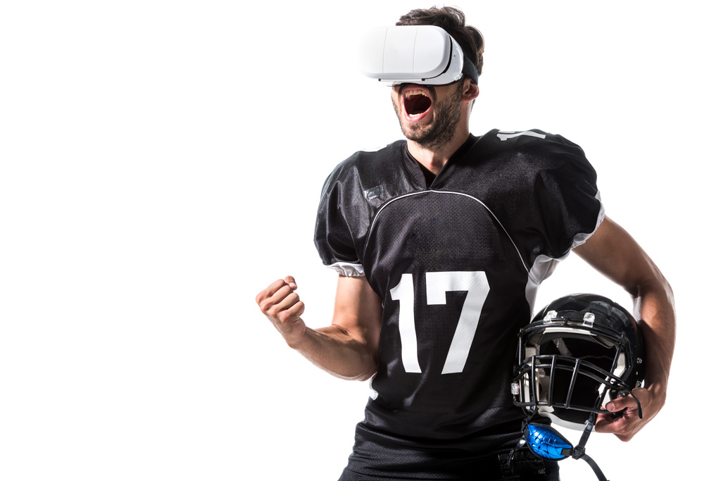 podekscytowany amerykański piłkarz w wirtualnej rzeczywistości zestaw słuchawkowy z hełmem izolowane na białym - Zdjęcie, obraz